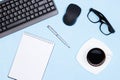Neat workplace table. Workspace minimal flatlay. Keyboard with mouse, blank notebook, pen, glasses, coffee cup on office desk Royalty Free Stock Photo