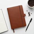 A neatly arranged flat lay features a brown leather-bound notebook with a strap, a lined open Royalty Free Stock Photo