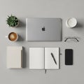 Gray surface a silver laptop with an Apple logo an open notebook with Royalty Free Stock Photo