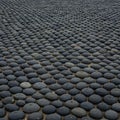 A neatly arranged pattern of round, smooth black stones covers the ground. The ston Royalty Free Stock Photo