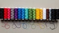 Row of spools of thread each in a different color displayed on Royalty Free Stock Photo
