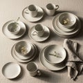 A neatly arranged set of white ceramic tableware, including plates, bowls, and cups, placed on a Royalty Free Stock Photo