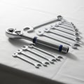 Arranged set of wrenches and a ratchet tool on a white surface. The Royalty Free Stock Photo
