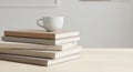 A neatly arranged stack of books with neutral-colored covers sits on a light wooden Royalty Free Stock Photo