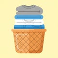 A neatly arranged stack of folded clothes, including sweaters and shirts, sits in a Royalty Free Stock Photo