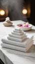 A neatly arranged stack of white towels sits on a marble surface. In the background, a Royalty Free Stock Photo