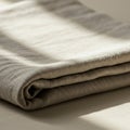 A neatly folded beige linen fabric is pictured, lying on a surface. The texture of the Royalty Free Stock Photo