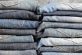 Neatly folded jeans in two piles on a gray background. Close-up of jeans in different colors. Denim background Royalty Free Stock Photo