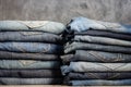 Neatly folded jeans in two piles on a gray background. Close-up of jeans in different colors. Denim background Royalty Free Stock Photo