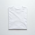 A neatly folded plain white T-shirt with a round neckline is placed on a smooth white Royalty Free Stock Photo