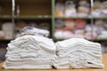 Neatly folded rows of white children's clothes on blurred background