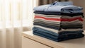 A neatly folded stack of clothes on a light colored wooden surface Royalty Free Stock Photo