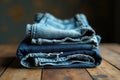 A neatly folded stack of denim pants showcasing various shades of blue, resting on a rustic wooden surface. Generative AI Royalty Free Stock Photo