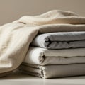 A neatly folded stack of fabric featuring four pieces in varying shades of beige, gray, a Royalty Free Stock Photo