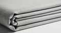 A neatly folded stack of light gray fabric, displaying a smooth, tight weave. The surface has a Royalty Free Stock Photo