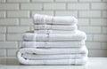 Neatly folded stack of plush white bath towels resting on clean surface, ready for use in hotel or spa. Soft texture evokes Royalty Free Stock Photo