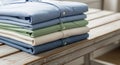 A neatly folded stack of shirts is placed on a wooden table with a weathered finish. Royalty Free Stock Photo