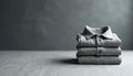 Neatly folded stack of three grey polo shirts on textured surface. Minimalist style, comfortable fabric, classic apparel choice Royalty Free Stock Photo