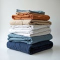 Neatly folded textiles form a tall stack on a clean white surface. Layers of fabric in neutral and blue tones are organized for Royalty Free Stock Photo