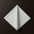 A neatly folded white cloth napkin sits against a dark brown background. The napkin Royalty Free Stock Photo