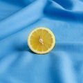 A neatly halved lemon Citrus limon is placed upright on a smooth blue fabric Royalty Free Stock Photo