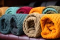 Neatly rolled quilts in various colors, showcasing comfort and warmth, arranged together.