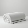 A neatly rolled, white blanket on a plain surface. It appears soft, with a textured surfa Royalty Free Stock Photo
