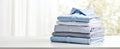 The neatly stacked collection of blue shirts on a clean table. AI generated image Royalty Free Stock Photo