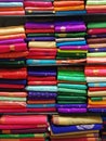 Neatly stacked colorful designer silk saris in racks in a textile shop. Incredible India