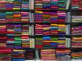 Neatly stacked colorful designer silk saris in racks in a textile shop. Incredible India