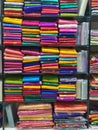 Neatly stacked colorful designer silk saris in racks in a textile shop. Incredible India