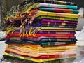 Neatly stacked colorful designer silk saris in racks in a textile shop. Incredible India