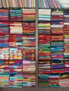 Neatly stacked colorful designer silk saris in racks in a textile shop. Incredible India