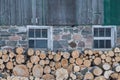 Neatly stacked firewood by an old Ontario Barn in winter