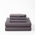 Neatly Stacked Gray Bedding Sheets and Pillowcases on White Background Royalty Free Stock Photo