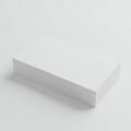 A neatly stacked pile of blank white business cards is placed on a smooth, white Royalty Free Stock Photo