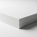 A neatly stacked pile of white paper sheets on a plain surface. The sheets are aligned smoothly, Royalty Free Stock Photo