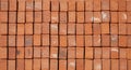 Neatly stacked red clay bricks, each rectangular and uniform in shape, create a Royalty Free Stock Photo