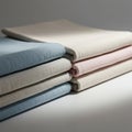 A neatly stacked set of folded fabrics in muted tones of blue, beige, and pink. The Royalty Free Stock Photo