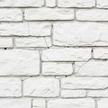 A neatly stacked stone wall featuring a pattern of rectangular, white stones. The Royalty Free Stock Photo