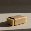A neatly wrapped bar of beige soap on a flat surface with soft lighting. The soap is Royalty Free Stock Photo