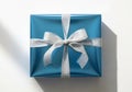 A neatly wrapped rectangular gift box in shiny blue paper with a silver satin ribbon tied in a bow. Royalty Free Stock Photo