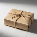 A neatly wrapped rectangular gift box sits on a light surface, covered in brown kraft Royalty Free Stock Photo