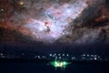 Nebula in galaxy over silhouette seaport  and fishing boat on night sky sea Royalty Free Stock Photo