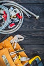 Necessary set of tools in the bag for plumbers on black vintage wooden background Royalty Free Stock Photo