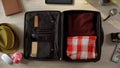 Necessary things neatly packed in suitcase, people going on vacation, top view