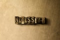 NECESSITY - close-up of grungy vintage typeset word on metal backdrop