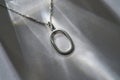 Neck chain with oval pendant on gray background Royalty Free Stock Photo