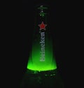 Neck of Heineken Lager Beer bottle full of foam. Neck of beer bottle with beer foam on dark background. Beer bubbles. Royalty Free Stock Photo