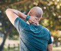 Neck pain, outdoor and man in a park with sport injury and muscle strain from fitness and workout. Exercise problem